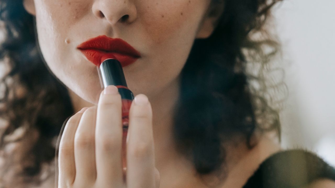 Aprenda a elaborar uma maquiagem com batom vermelho de forma impecável - Foto: Canva
